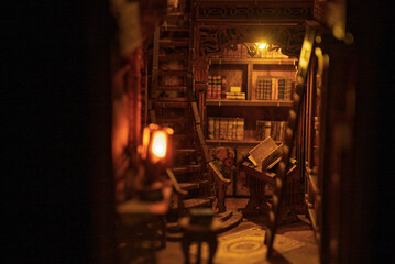 Magical wooden book nook miniature library diorama glowing with warm lights in the dark. Intricate...