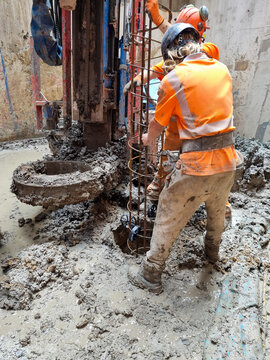 Construction Workers Installing Rebar Cage During Foundation Piling Operations
