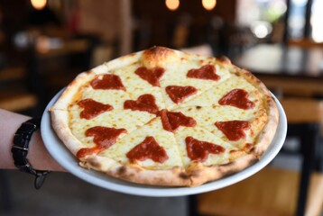 Freshly baked pizza with heart-shaped ketchup decorations, perfect for Valentine&rsquo;s Day or romantic occasions.