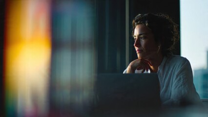 Contemplative woman working on laptop