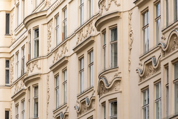 Fototapeta premium Detailed fragment of the facade of an old European house with decorative stucco molding and windows