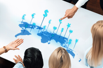 Dynamic office scene showcasing professionals analyzing a digital world map with currency symbols, emphasizing global finance and collaboration in business strategies. Trope