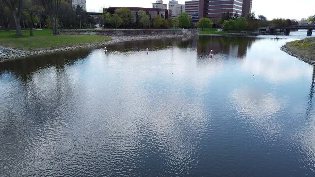 Flint, Michigan skyline and the Flint River. Known widely for their water quality and safety issues. Shot in time lapse, tilting up from the river to the skyline on a beautiful day.