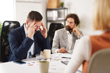Group of professionals collaborate in office setting, sharing ideas and discussing strategies while working towards common goals during a brainstorming session.
