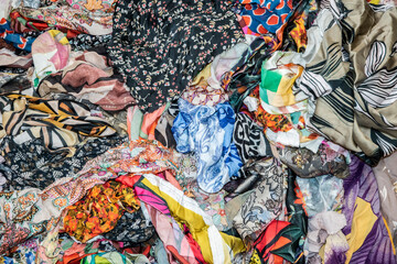 Close-up of mixed colorful fabric scraps in fashion studio, symbolizing textile design, reuse, creativity, and sustainable clothing production.