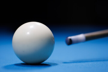 Boule de billard blanche proche avec sa queue