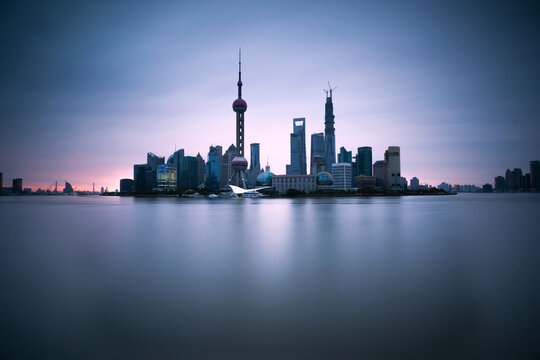 Shanghai Pudong skyline at sunset reflected into water, China