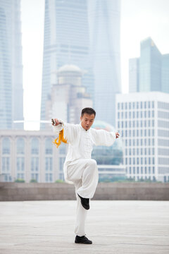 Tai Chi Practitioner in White Silk Uniform Executing Martial Arts Movement, Shanghai, China