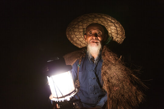 Portrait of old chinese fisherman with lantern on the Li river, Yangshuo, Guilin, China