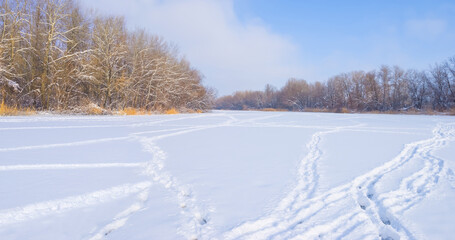 frozen winter river with forest on coast at the bright day