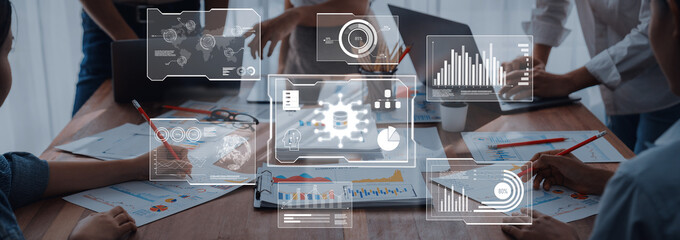 A diverse team collaborates in a modern office setting, analyzing data and strategies displayed digitally, enhancing communication and productivity during discussions. Trope