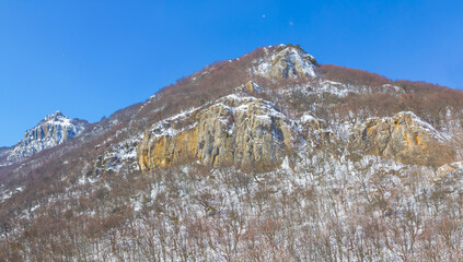 alone mount top in a snow on blue cloudy sky background