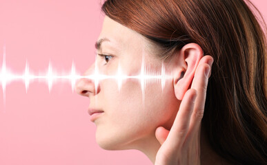 Young woman and sound waves near her ear on pink background, closeup. Banner design