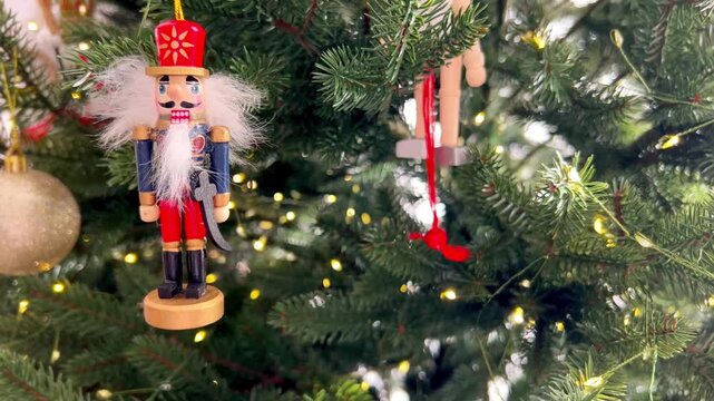 Wooden Nutcracker Christmas ornament hanging on a decorated Christmas tree. Traditional holiday decor with festive lights and classic New Year atmosphere, winter celebration and seasonal decoration 