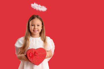 Fototapeta premium Cute little girl dressed as cupid with gift box on red background. Valentine's Day celebration