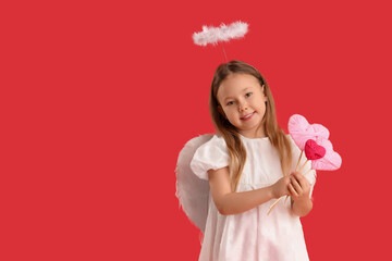 Fototapeta premium Cute little girl dressed as cupid with hearts on red background. Valentine's Day celebration