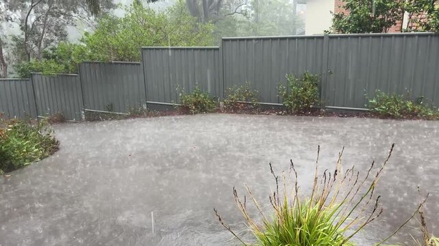 Extremely heavy rain splashing and running like a river down a concrete driveway