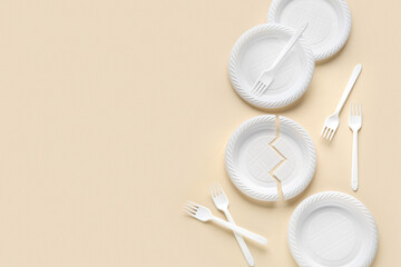 White plastic plates and forks on beige background
