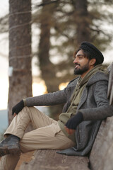 Smiling man in traditional pakol hat enjoying a winter day. Use for concepts of happiness, exploration, and outdoor lifestyle.