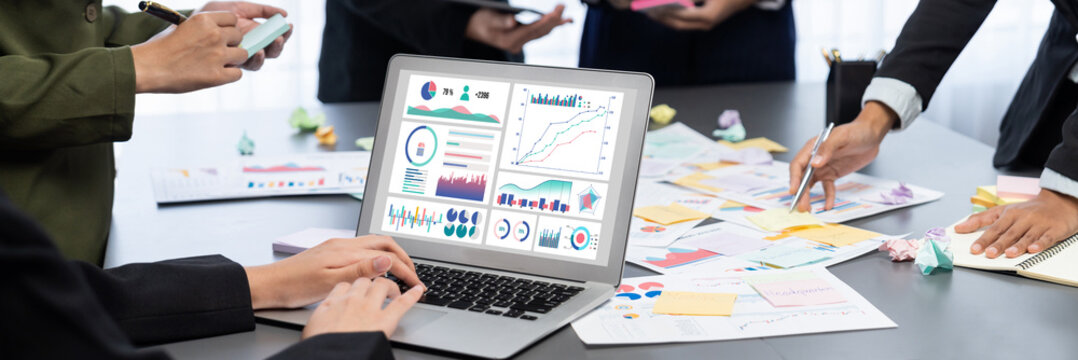 Analyst team use sticky note for creative and analytic brainstorm for business idea with BI data dashboard on laptop screen. Analysis financial data visualization tech for marketing strategy. Prodigy - Powered by Adobe