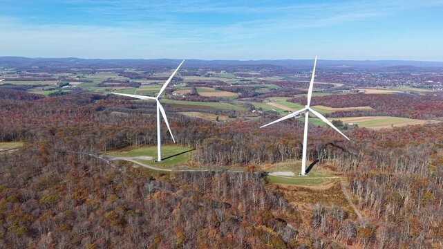 VIRGINIA - 11.10.2025 - Wonderful close-up aerial panorama of wind power mills towering over an autumnal forest in Virginia.