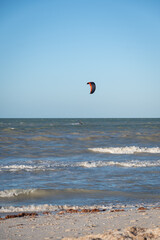 ide shot of an athletic woman kitesurfing in the sea.