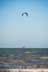 ide shot of an athletic woman kitesurfing in the sea.