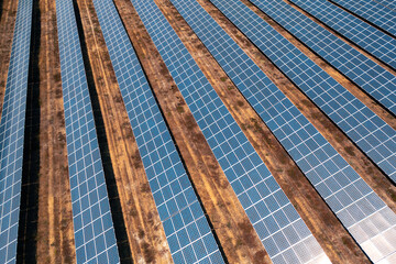 Aerial drone view rows of solar panels arranged on ground at modern renewable power plant, generating clean sustainable electricity and promoting eco friendly energy solutions