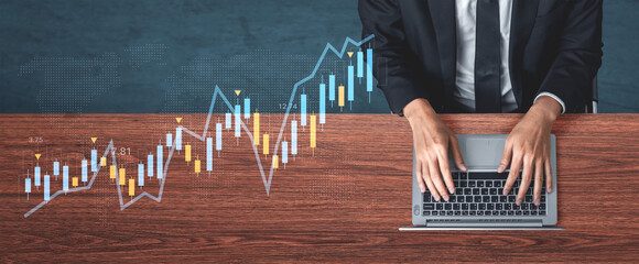 A business professional engages with market data on a laptop, showcasing financial charts for analysis in a modern office environment, reflecting growth and strategy. Gantry