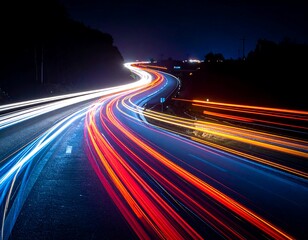 Long exposure shot of a highway at night, showing trails of light from passing vehicles curving through the scene