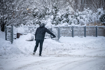Człowiek odśnieżający drogę po intensywnych opadach śniegu.
