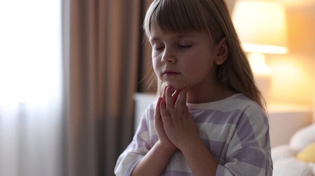 Cute little girl praying at home, camera moving