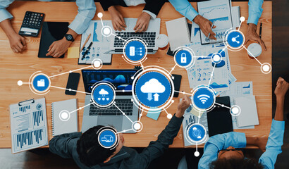 A vibrant office setting showcases a team collaborating on cloud computing with digital icons and business analytics, highlighting modern technology and teamwork. Amity