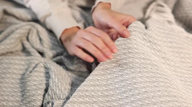 Woman touching soft light grey fabric, closeup