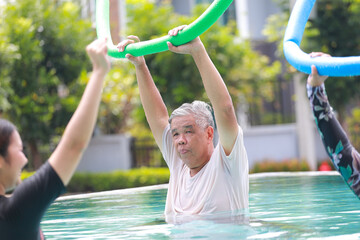 Health center staff teach elderly exercises to help them recover in the water while in an outdoor...