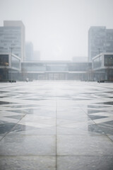 Fototapeta premium Minimalist Urban Architecture with Large Gray Concrete Plaza in Foggy Cold Weather