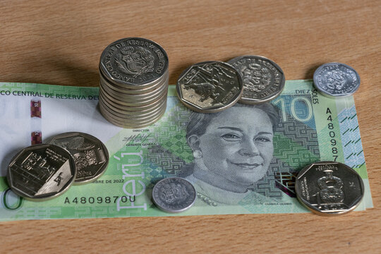 Sol peruano, monedas y billetes del sol peruano, moneda oficial del Per&uacute;, sobre superficie de madera
