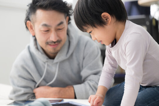 Holiday time spent learning together using a tablet as parent and child Father and son's joyful parenting