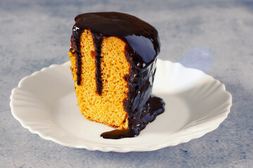 Slice of Brazilian Carrot Cake with Chocolate Frosting on a White Plate with space for text