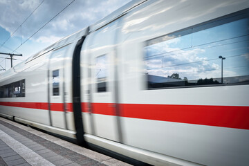 Dynamic shot of a passing German ICE train. Symbol for modern rail transport, high speed, and travel in Germany. Professional motion blur