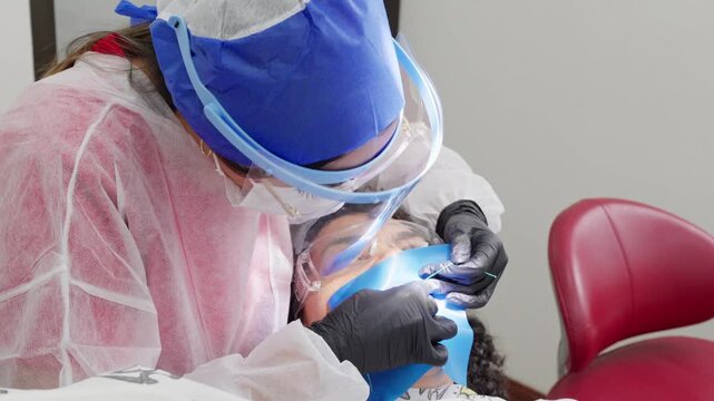 Dentist placing rubber dam during dental procedure