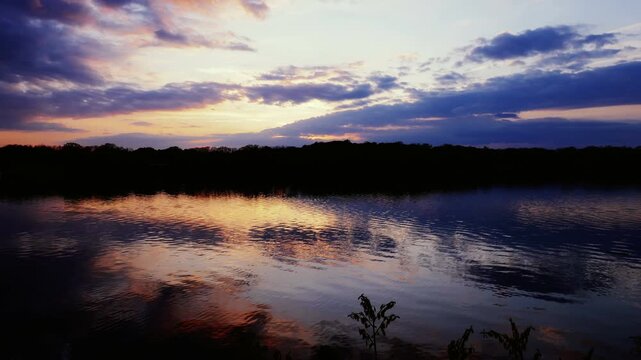 Sunset during early spring on Lake Chapin in southwest Michigan, United States. Shot in time lapse.