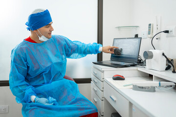 Naklejka premium Dentist examining dental x-ray on laptop in clinic