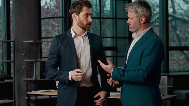 Two adult Caucasian businessmen partners discussing business deal in office professional males men guys leader talking colleague financial manager client consulting strategy corporate teamwork meeting