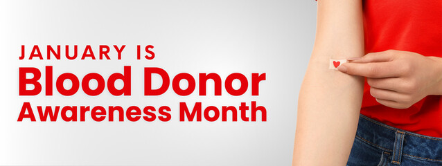 A hand places a heart sticker for blood donor awareness