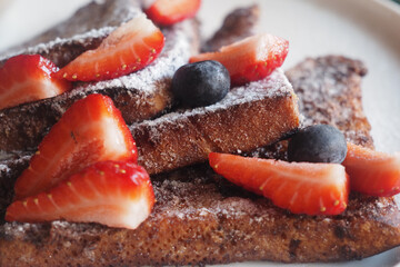 French toast with strawberries and blueberries on a plate
