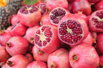 Pomegranates stacked in a market on a sunny day