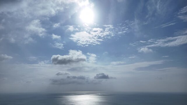 Aerial view of the morning sun and a slightly cloudy blue sky hyperlapse with beautiful sea