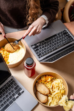 People eating takeaway lunch while working