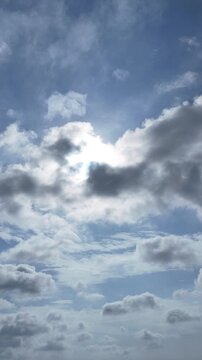 Aerial view of the morning sun and a slightly cloudy blue sky hyperlapse. Vertical video